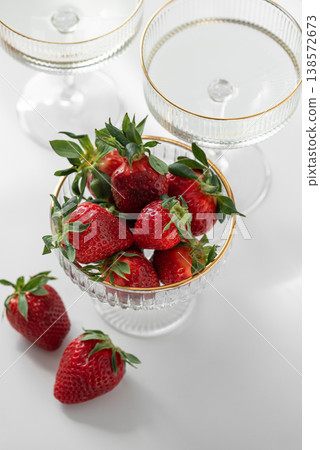Champagne Glasses with Strawberries on White Table into Cozy Living Room Champagne Glasses with Strawberries on White Table into Cozy Living Room 138572673