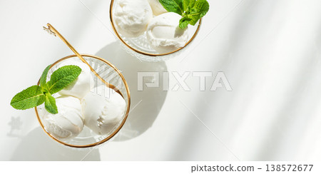 Vanilla Ice Cream in Elegant Glass Bowls on White Table with Sunlight Vanilla Ice Cream in Elegant Glass Bowls on White Table with Sunlight 138572677