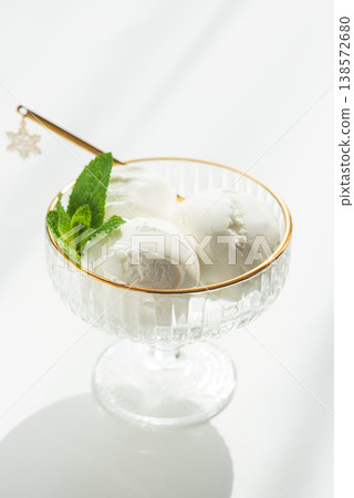 Vanilla Ice Cream in Elegant Glass Bowls on White Table with Sunlight Vanilla Ice Cream in Elegant Glass Bowls on White Table with Sunlight 138572680