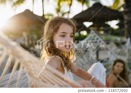 Girl relaxing in hammock during tropical family vacation. Girl relaxing in hammock during tropical family vacation. 138572692