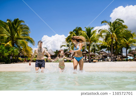 Family enjoying tropical beach vacation at luxury resort. Family enjoying tropical beach vacation at luxury resort. 138572701