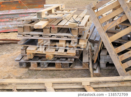Wooden pallets at a construction site. Used stacked wooden pallets used for storing building materials Wooden pallets at a construction site. Used stacked wooden pallets used for storing building materials 138572709