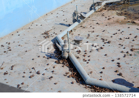 Technical equipment at the bottom of a drained city fountain, requiring post-winter cleaning. 138572714