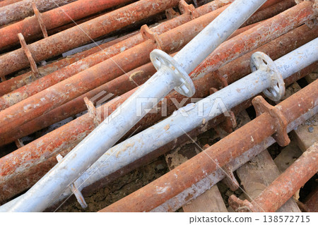 Industrial metal supports with flanges with signs of heavy use and oxidation, stored outdoors. Industrial metal supports with flanges with signs of heavy use and oxidation, stored outdoors. 138572715