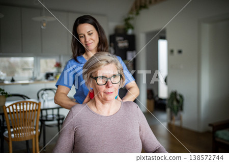 Physiotherapist helping senior woman with neck exercise, home therapy session. Physiotherapist helping senior woman with neck exercise, home therapy session. 138572744