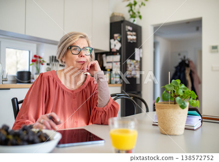 Senior woman working on tablet at home office during retirement. Senior woman working on tablet at home office during retirement. 138572752
