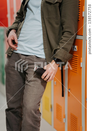 Teen student drinking an energy drink in school hallway. 138572758