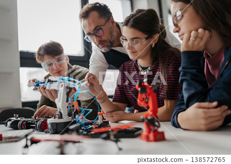 High school students working on robotics project with their teacher. 138572765