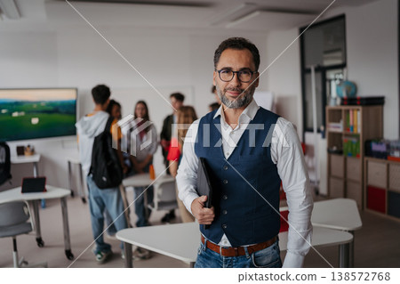 Teacher holding a tablet in modern high school classroom. Teacher holding a tablet in modern high school classroom. 138572768