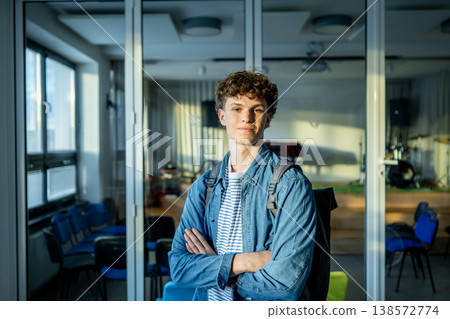 Confident teen student standing in modern classroom. Confident teen student standing in modern classroom. 138572774