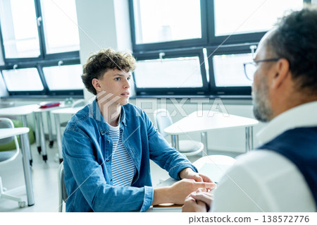 Teacher supporting struggling student with learning difficulties during lesson. 138572776