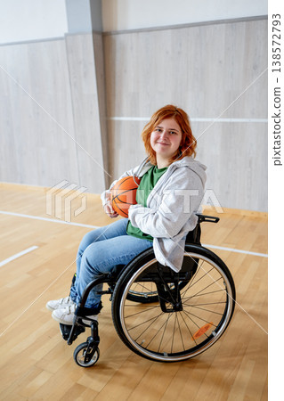 Young woman in wheelchair playing basketball. 138572793