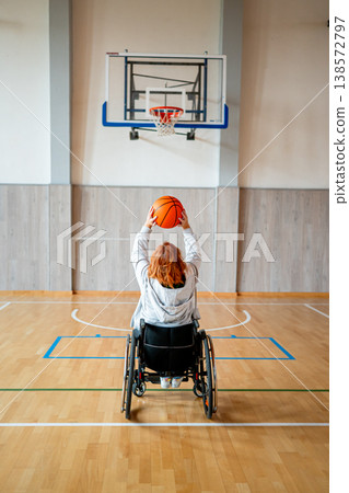 Wheelchair basketball player shooting ball towards hoop. Wheelchair basketball player shooting ball towards hoop. 138572797