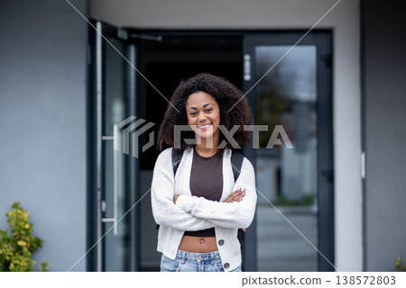 Confident teen student standing in front of school building. Confident teen student standing in front of school building. 138572803