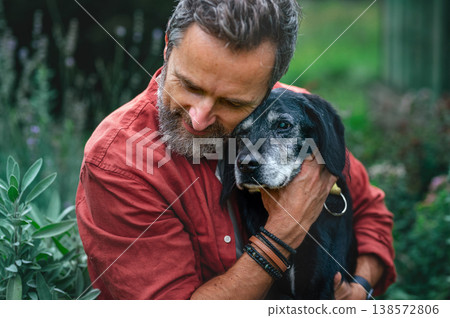 Man hugging senior dog with affection. Man hugging senior dog with affection. 138572806