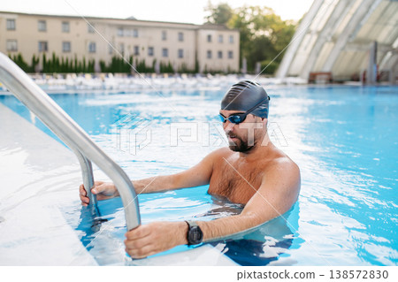 Male swimmer getting out of the pool after swim training. 138572830