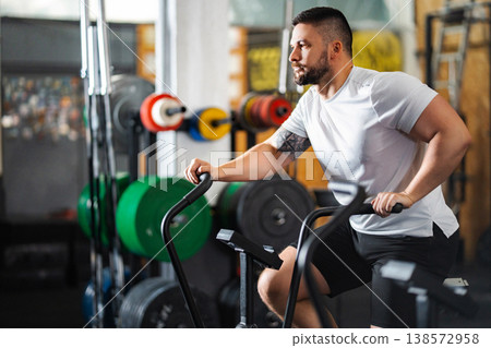 Man exercising on air bike doing cardio workout Man exercising on air bike doing cardio workout 138572958