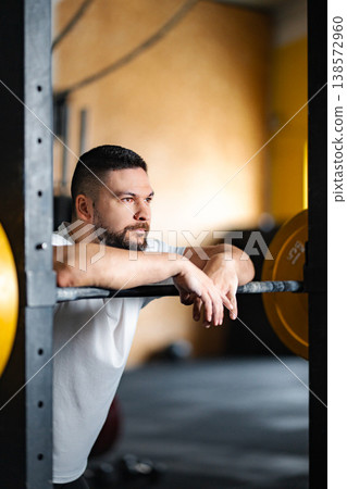 Male athlete resting during weightlifting workout in gym Male athlete resting during weightlifting workout in gym 138572960