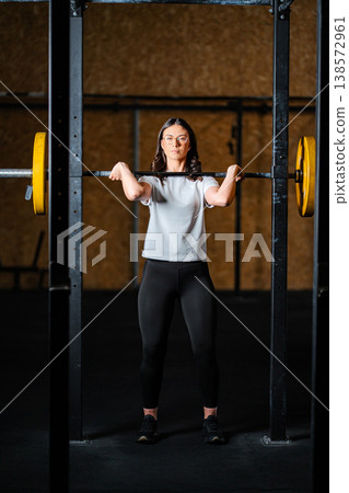 Woman training in gym doing front squat exercise 138572961