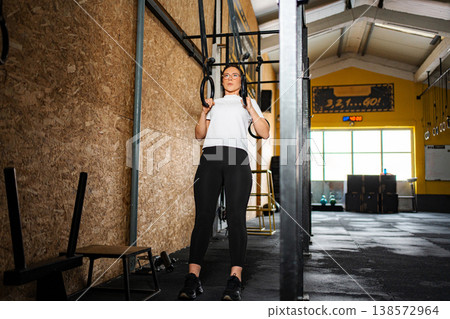 Woman preparing for workout on gymnastics rings in gym 138572964