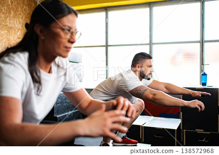 Two people squatting during fitness workout in gym Two people squatting during fitness workout in gym 138572968