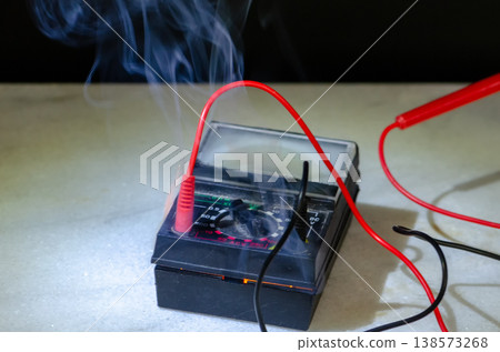 Smoking multimeter with wires after short circuit and electrical overload Smoking multimeter with wires after short circuit and electrical overload 138573268