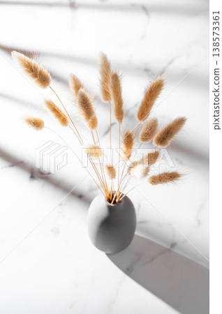 Minimalistic bouquet of dried herbs in a ceramic vase on a marble background. Minimalistic bouquet of dried herbs in a ceramic vase on a marble background. 138573361