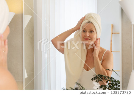A Radiant Woman Happily Engaging in Her Skincare Ritual in a Bright, Cheerful Bathroom Decorated with Plants A Radiant Woman Happily Engaging in Her Skincare Ritual in a Bright, Cheerful Bathroom Decorated with Plants 138573780