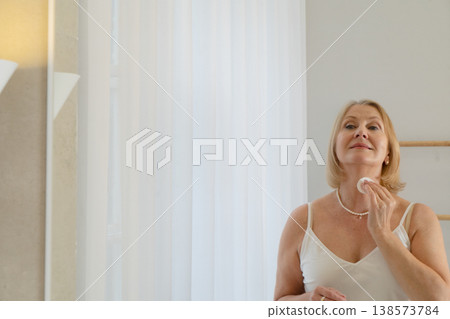 A Radiant Woman Happily Engaging in Her Skincare Ritual in a Bright, Cheerful Bathroom Decorated with Plants A Radiant Woman Happily Engaging in Her Skincare Ritual in a Bright, Cheerful Bathroom Decorated with Plants 138573784