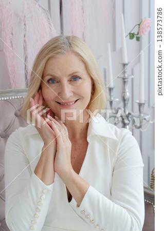 A woman is using a Gua Sha tool for a facial massage, promoting relaxation and enhancing her beauty routine 138573786