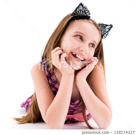 Cute teen girl wearing black laced ears of a cat, lying on the floor, smiling Cute teen girl wearing black laced ears of a cat, lying on the floor, smiling 138574327