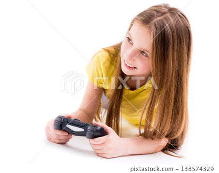 Concentrated and focused on winning a computer game girl, lying with a joystick Concentrated and focused on winning a computer game girl, lying with a joystick 138574329