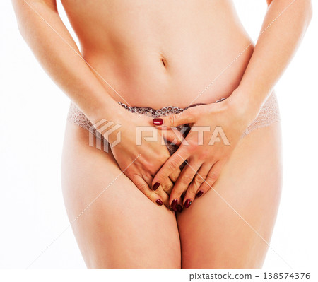 Attractive woman in pastel underwear standing and covering her abdomen, isolated on a white background Attractive woman in pastel underwear standing and covering her abdomen, isolated on a white background 138574376