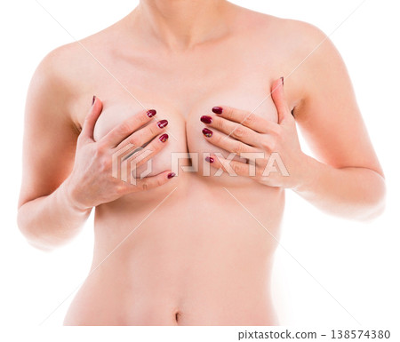 Naked girl holding her breast isolated on a white background 138574380