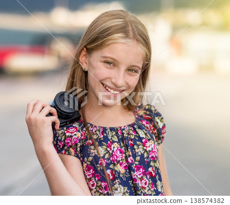 Beautiful little girl with camera, summer outdoor 138574382