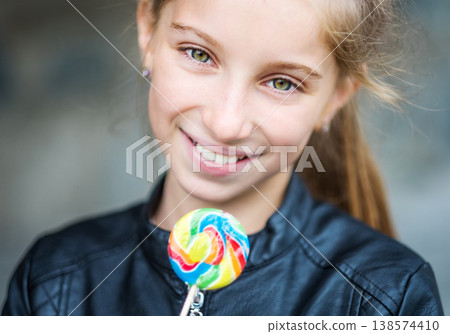 Beautiful little girl with candy, outdoor Beautiful little girl with candy, outdoor 138574410