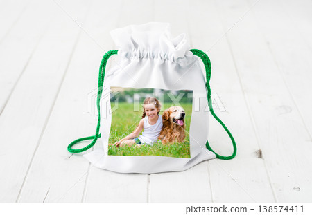 white gift bag from textile materials with colorful print sitting on the white wooden table white gift bag from textile materials with colorful print sitting on the white wooden table 138574411