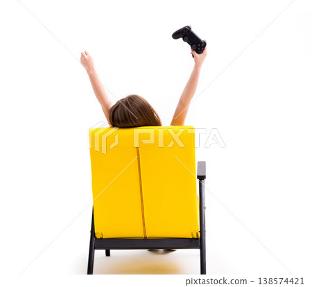 Girl playing computer games on console sitting in yellow bright leather chair, back to camera Girl playing computer games on console sitting in yellow bright leather chair, back to camera 138574421