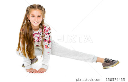 Cute little girl do stretching exercises in grey sportwear isolated on white abckground 138574435