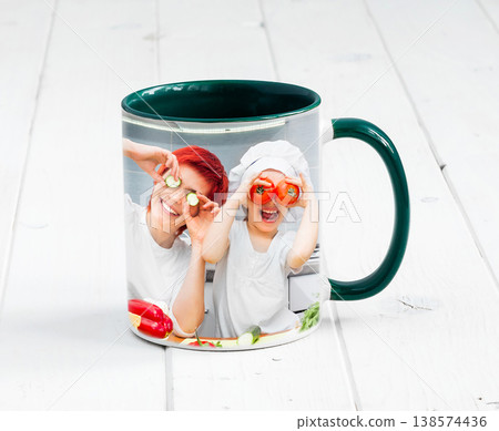 Big green cup with dark green handle and print of a kids cooking something 138574436
