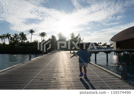 Japanese toddler walking among the overwater villas in the Maldives Japanese toddler walking among the overwater villas in the Maldives 138574490