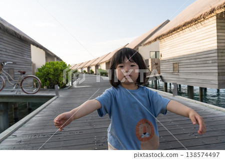 Japanese toddler walking among the overwater villas in the Maldives Japanese toddler walking among the overwater villas in the Maldives 138574497