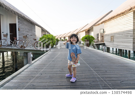 Japanese toddler walking among the overwater villas in the Maldives Japanese toddler walking among the overwater villas in the Maldives 138574498