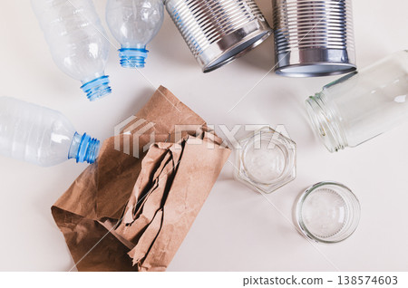 Paper, glass, metal and plastic for separate waste collection on the table top view Paper, glass, metal and plastic for separate waste collection on the table top view 138574603