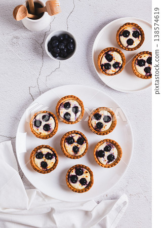 Mini cakes with cottage cheese and berries on a plate on the table top and vertical view Mini cakes with cottage cheese and berries on a plate on the table top and vertical view 138574619