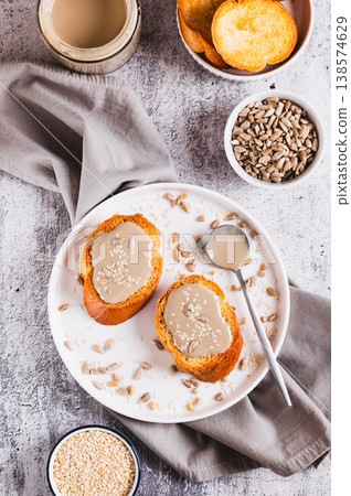 Toast with sesame and sunflower tahini on a plate on the table top and vertical view Toast with sesame and sunflower tahini on a plate on the table top and vertical view 138574629