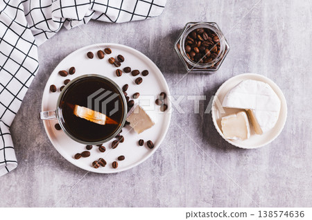 Black coffee with a piece of brie cheese in a glass on the table top view Black coffee with a piece of brie cheese in a glass on the table top view 138574636