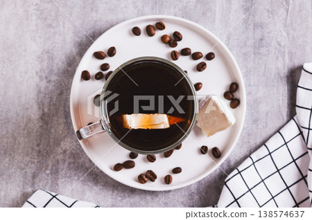 Close up of black coffee with a piece of brie cheese in a glass on the table top view Close up of black coffee with a piece of brie cheese in a glass on the table top view 138574637
