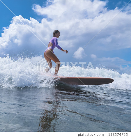 Teen Woman Practicing Stance On Surfboard Amid Gentle Ocean Colors And Clouds Teen Woman Practicing Stance On Surfboard Amid Gentle Ocean Colors And Clouds 138574735