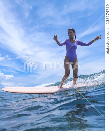 Vibrant Female Surfer Demonstrating Skill Amidst Powerful Ocean Currents Vibrant Female Surfer Demonstrating Skill Amidst Powerful Ocean Currents 138574739